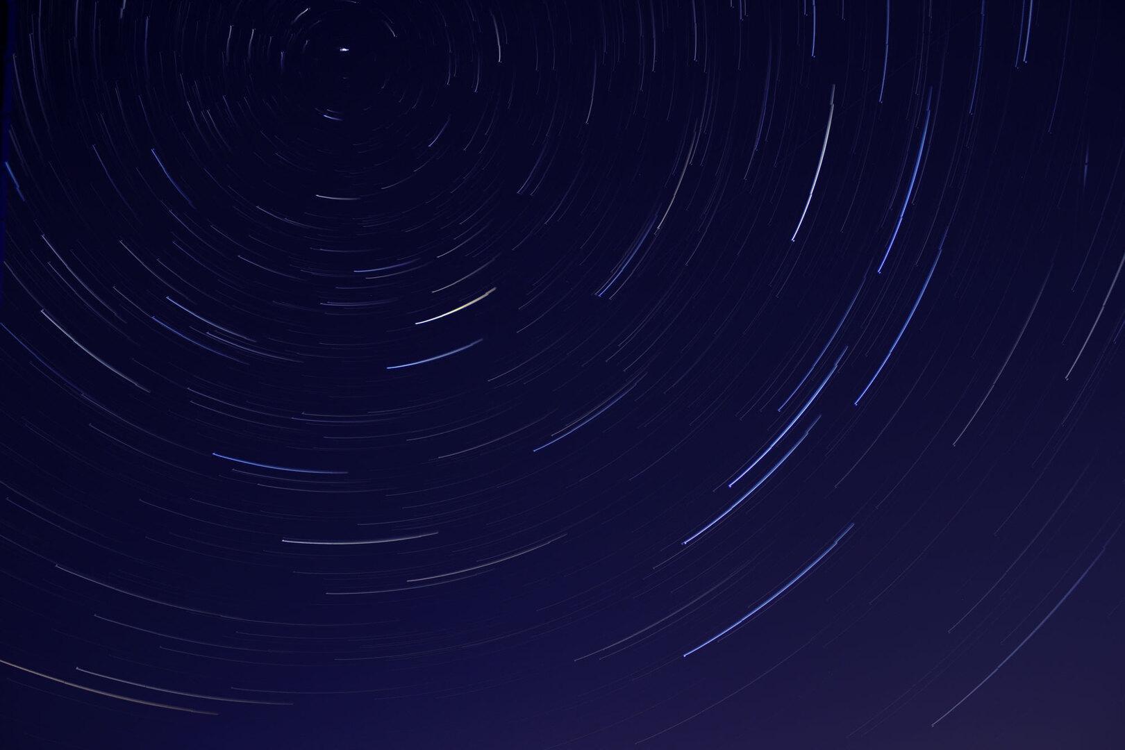 Star trails streaking across a deep blue night sky