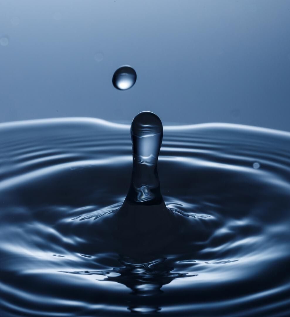 Goutte d'eau rebondissant à la surface, formant des ondes concentriques